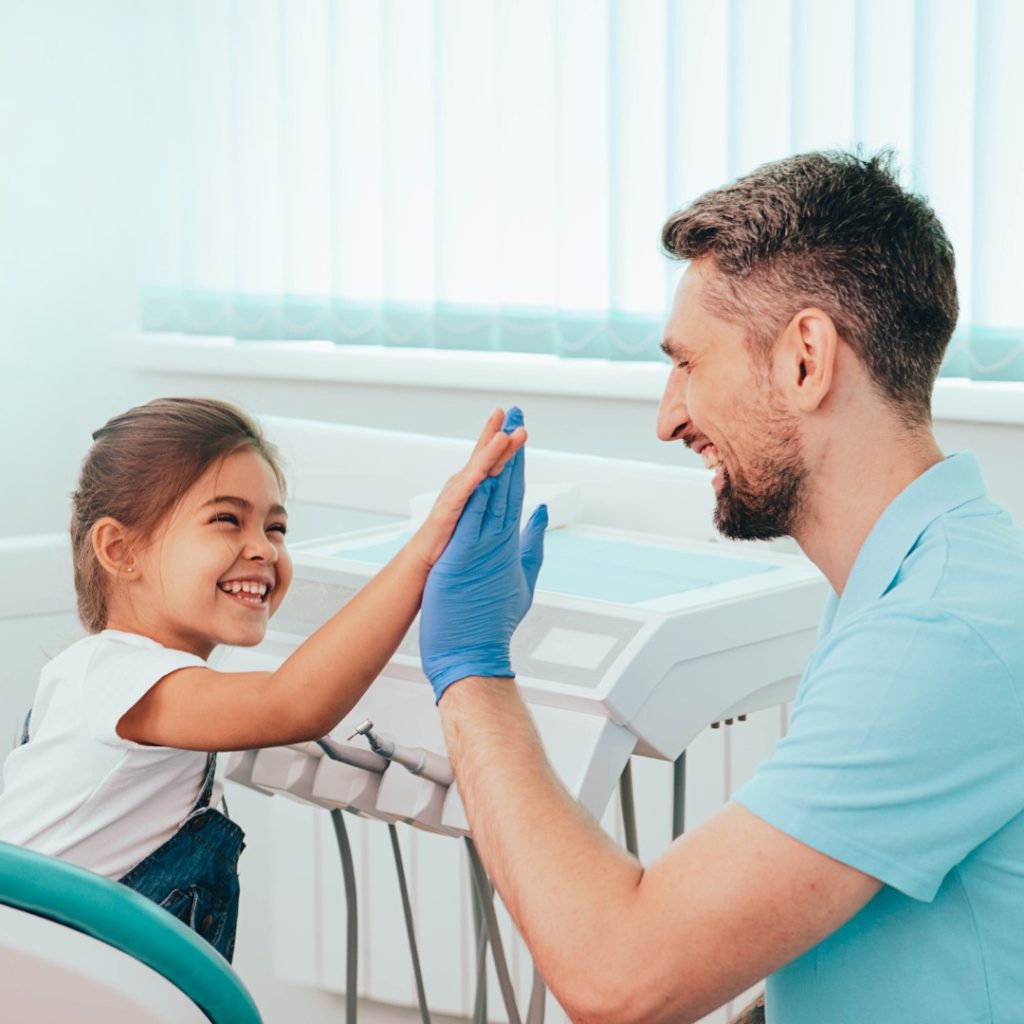 dentist and kid patient doing a high five